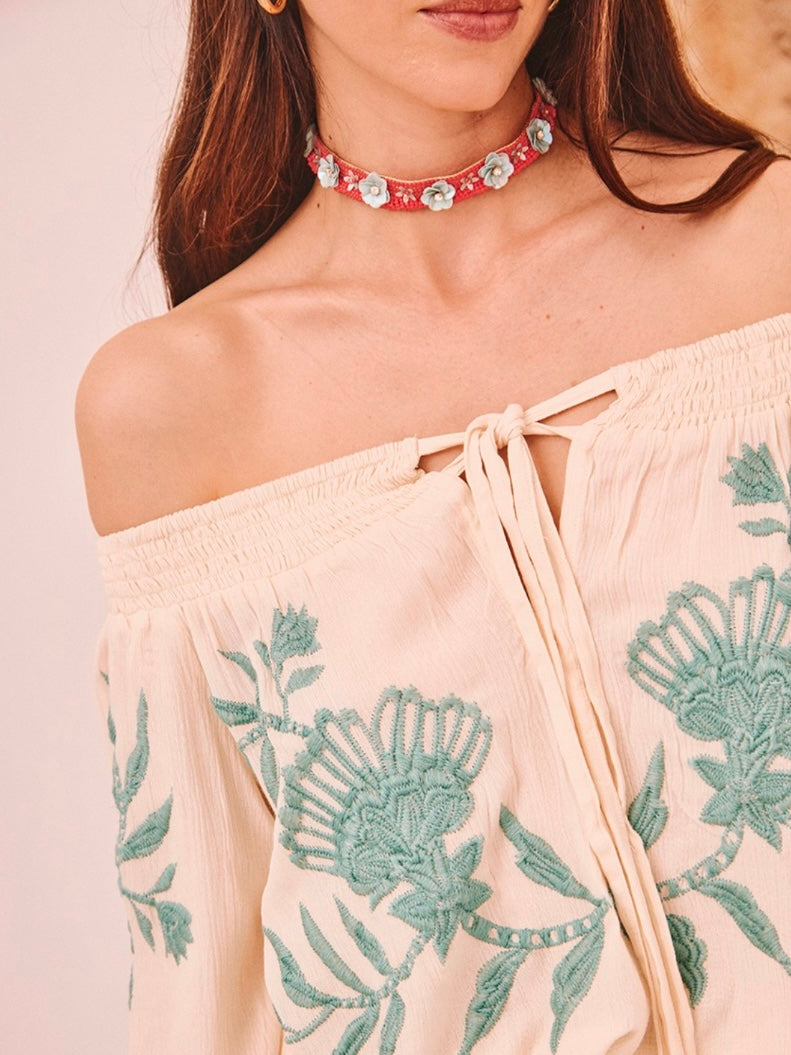 Detalle del escote barco con goma y bordado artesanal en color agua sobre fondo vainilla de la blusa BOHEMIAN.