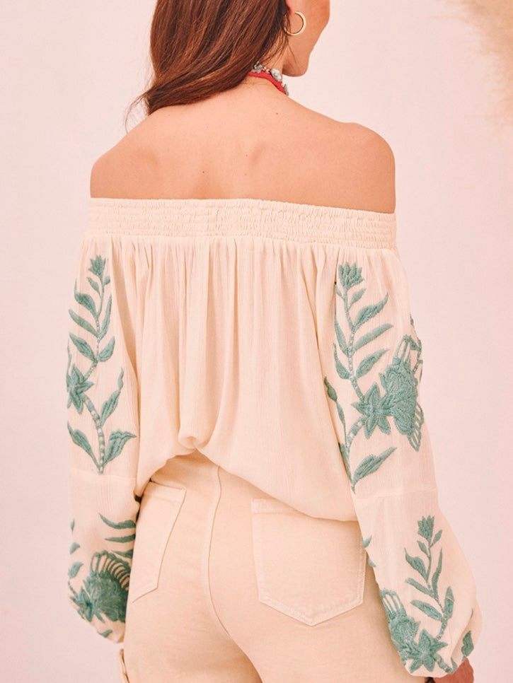 Detalle del escote barco con goma y bordado artesanal en color agua sobre fondo vainilla de la blusa BOHEMIAN.